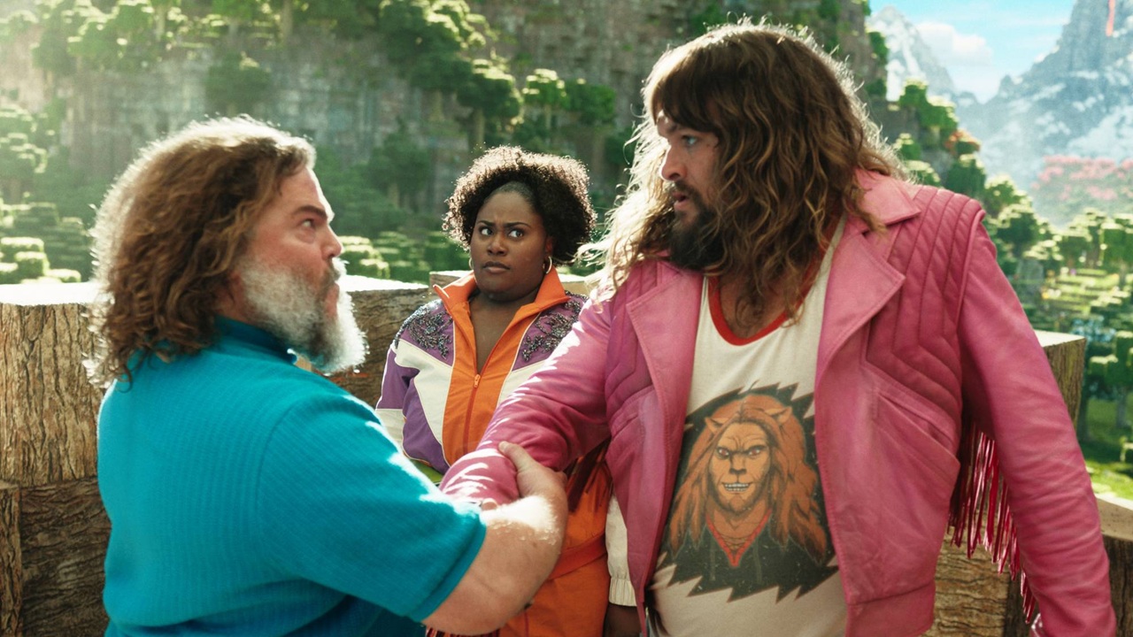 Steve (Jack Black) welcomes former game champion Garrett (Jason Momoa) and real estate agent Dawn (Danielle Brooks) to the lush, mountainous, blocky land of Overworld in A Minecraft Movie.