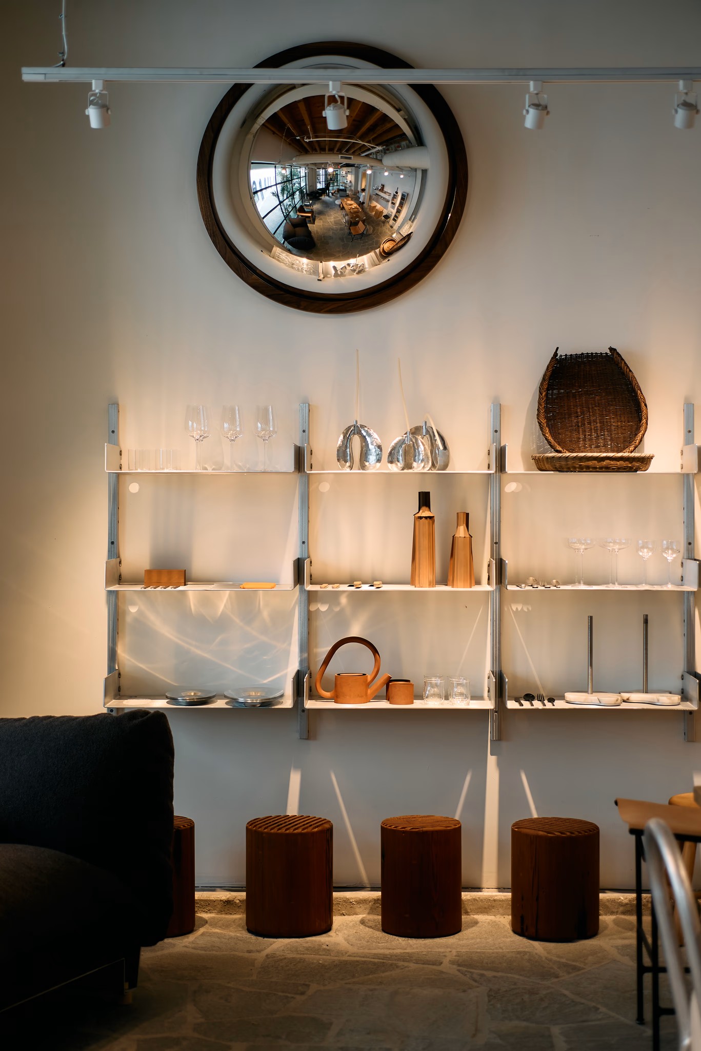 An industrial-style showroom filled with wood, chrome, and tempered glass creations as well as upholstered furniture.