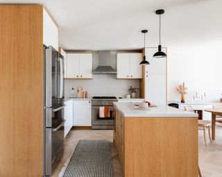 A kitchen with oak and white painted cabinets and oak island