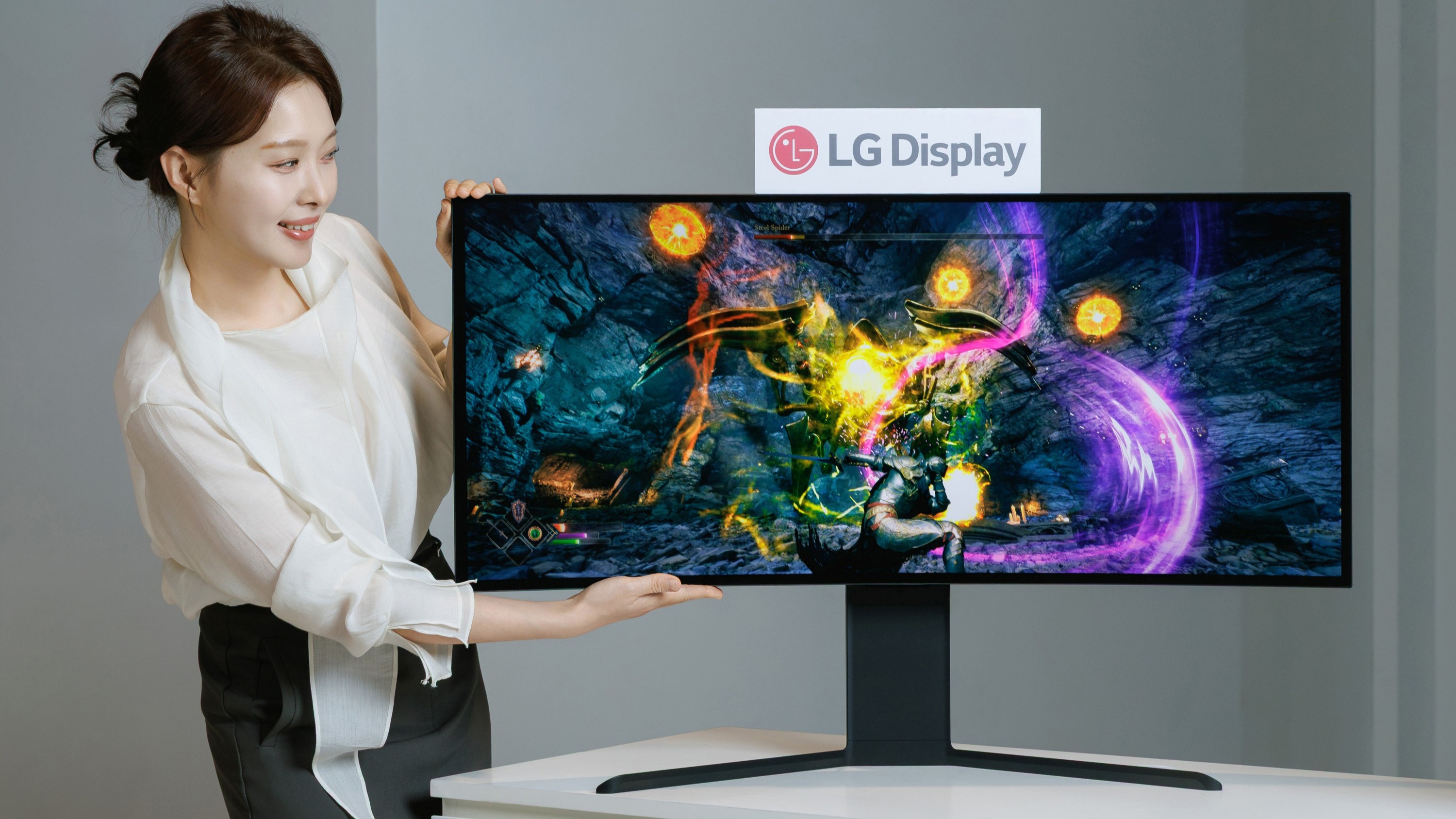 A woman showcasing LG's 39-inch 5K2K OLED gaming monitor