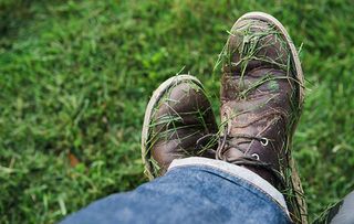 Man's shoes covered in freshly mown grass