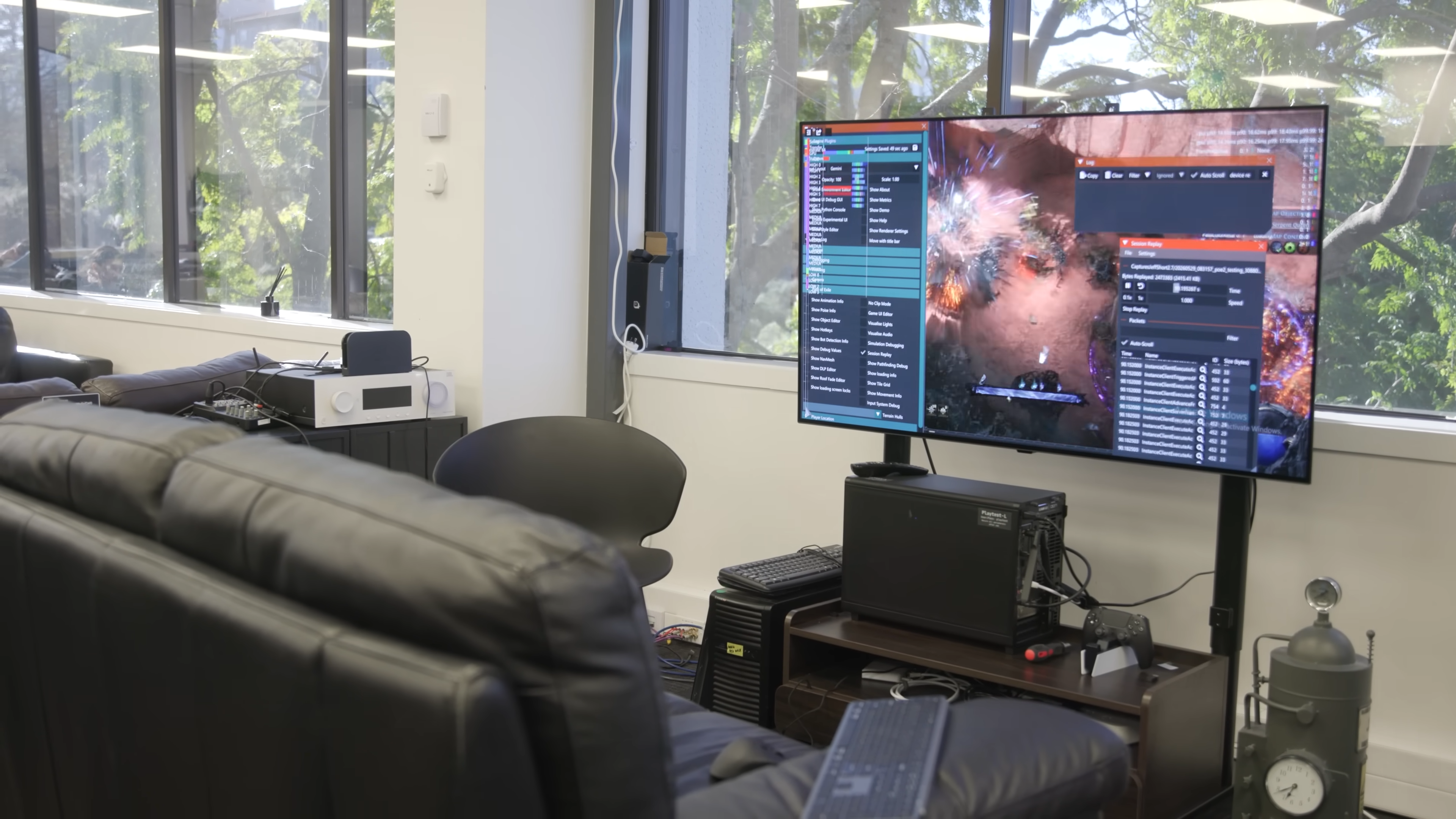 A screencap of a video by Path of Exile 2 developer Grinding Gear Games. A PC setup running the game is seen in front of an empty chair in an office.