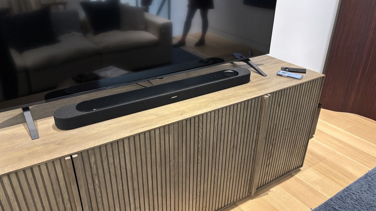 Bose Lifestyle Ultra Soundbar in front of a TV on a sidetable