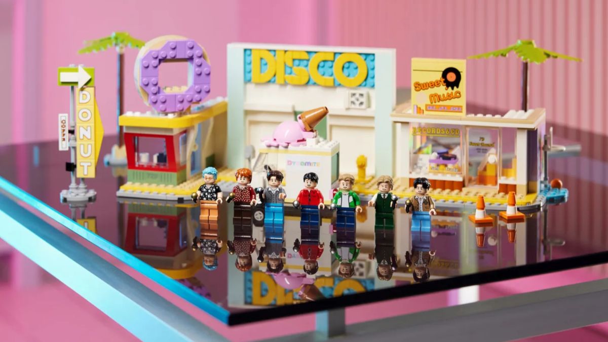 Lego BTS Dynamite sets with the Disco building in the background and Minifigs of the full band