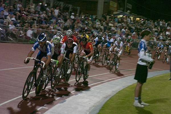 The field head down the back straight beside support crews.