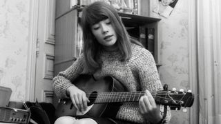 Francoise Hardy plays an acoustic guitar. Hardy, very popular in France, is known for writing many of her own songs. 