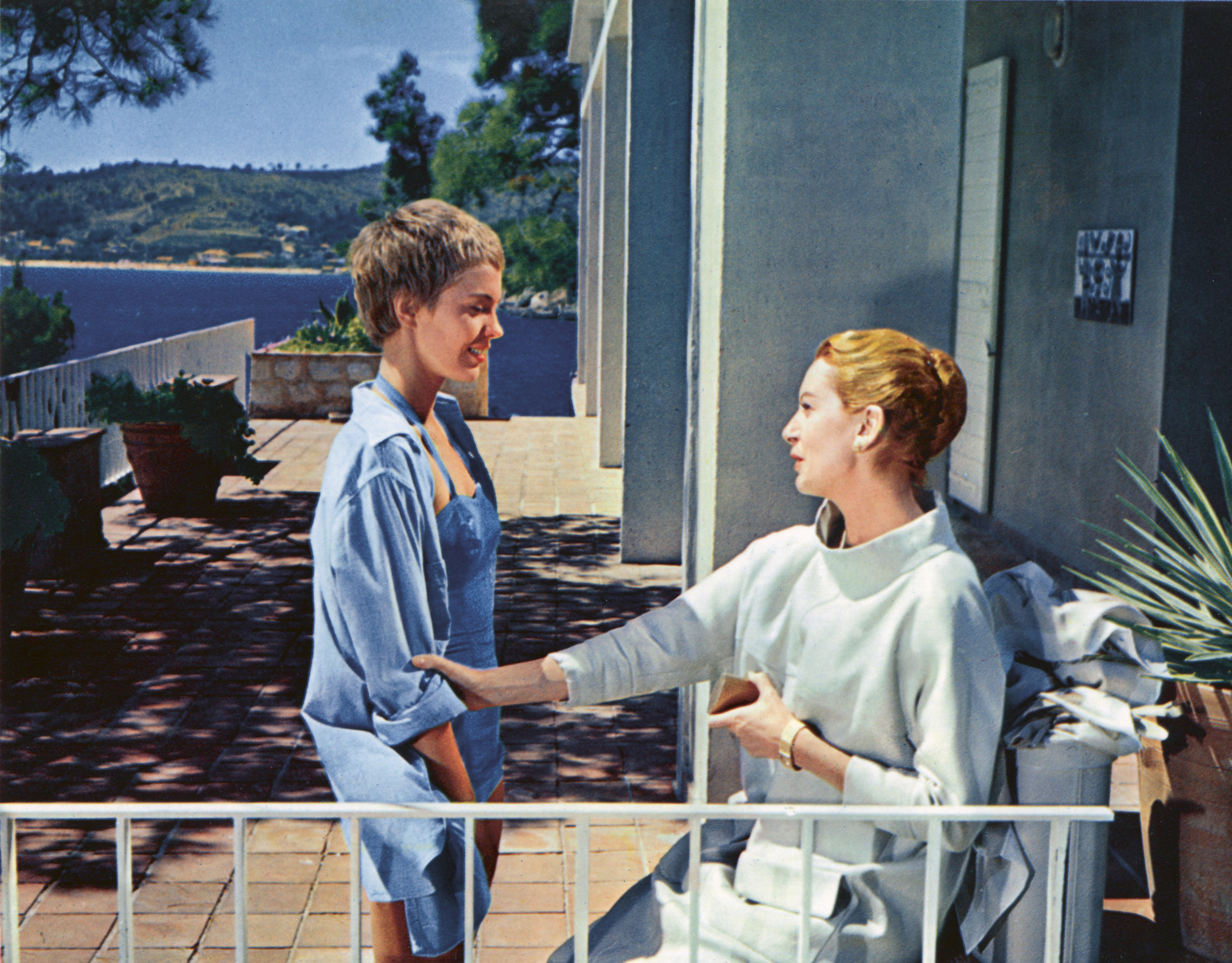 a still of jean seberg and deborah kerr sitting on a patio by the ocean in the movie bonjour tristesse