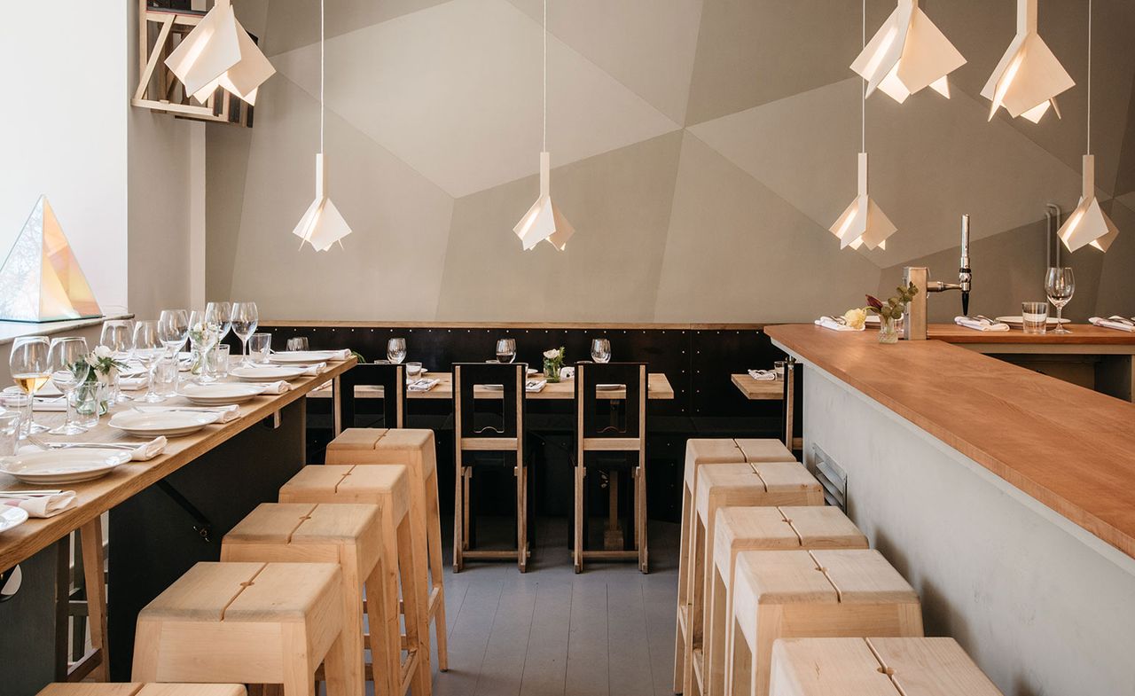 Dining area featuring black and natural wood furniture and abstract light fittings