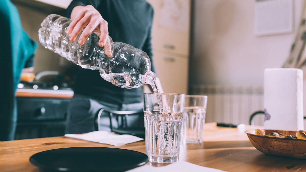 woman pouring herself a glass of water