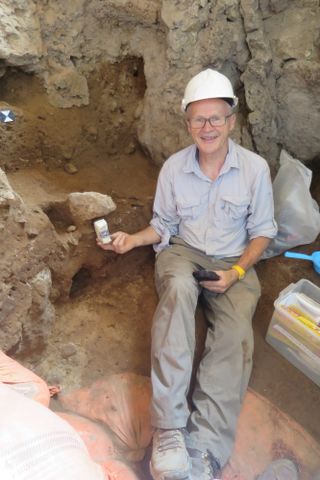 Study senior author Graeme Barker, a professor in the Department of Archaeology at the University of Cambridge, sits in front of the newfound Neanderthal remains. Barker is holding a soil block that will be analyzed at Cambridge in England.