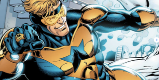 Booster Gold, a blue and gold-clad superhero, is smiling