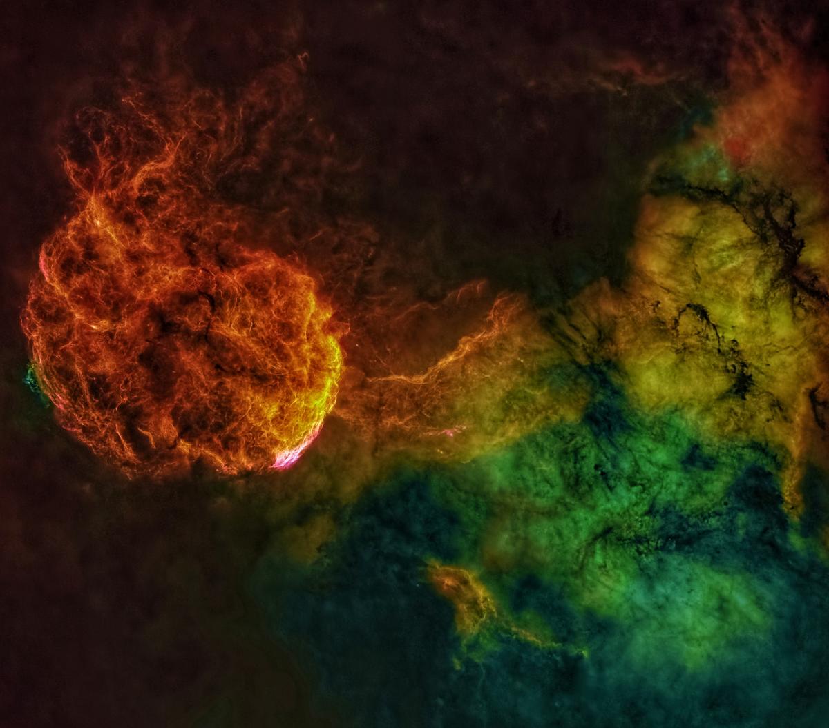 A vividly colored swirl of gasses and plasma concentrate on a near-spherical nebula cloud that resembles a jellyfish.