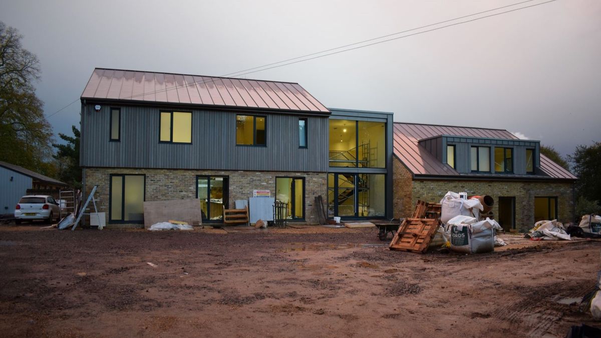 A self build home with a timber clad second storey and a metal roof