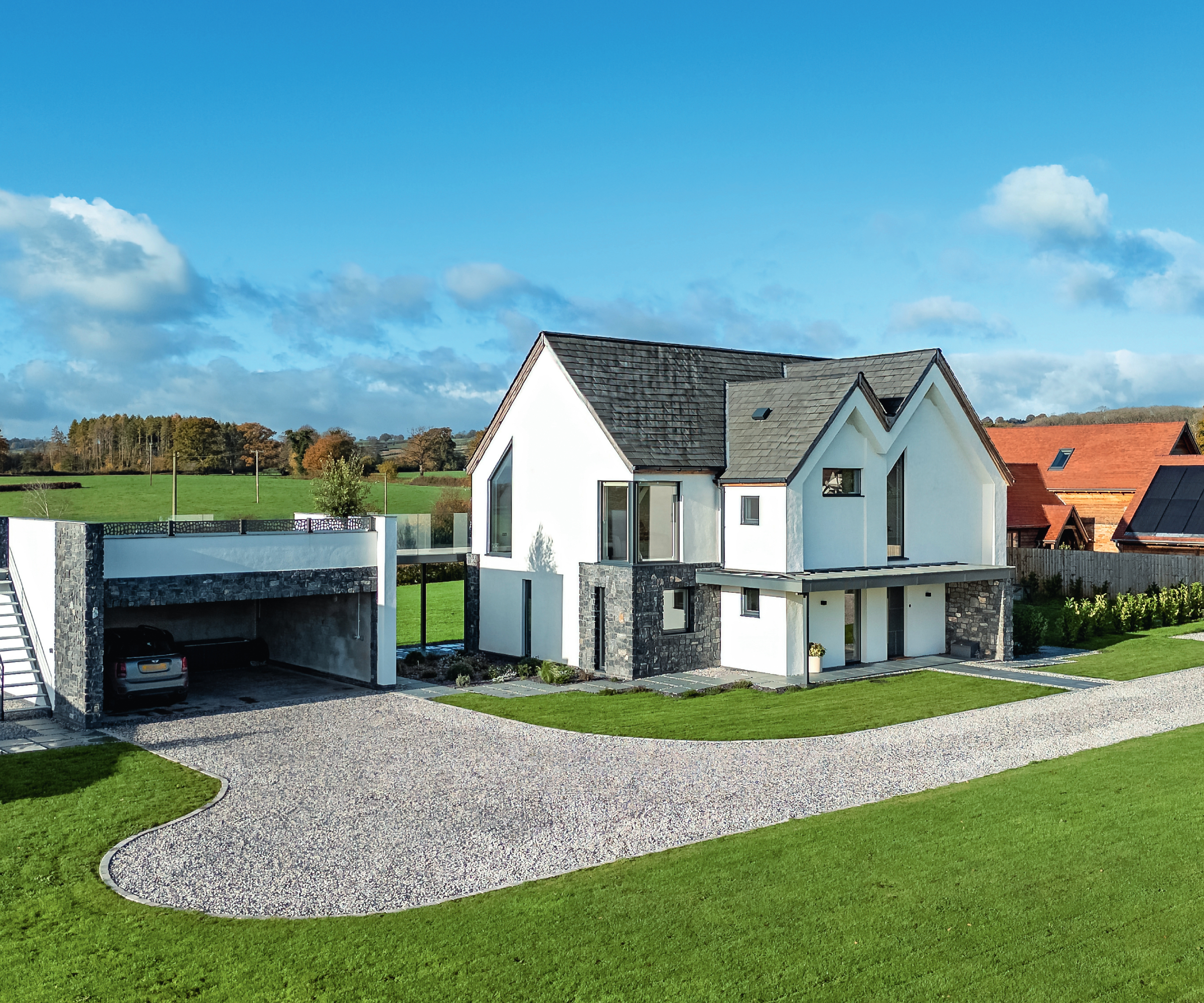 modern white rendered double storey house with separate car port