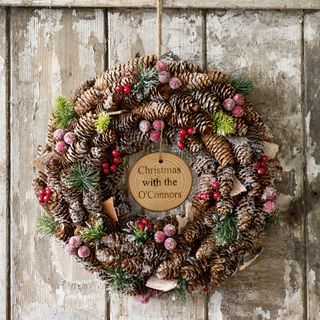 personalised frosted berries wreath by dibor with an abundance of berries natural pinecones green fir sprigs and decorative wooden curls