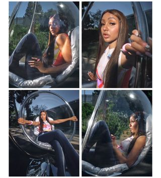 PinkPantheress sitting in a clear circle chair wearing a printed top with black pants and chunky jewelry.