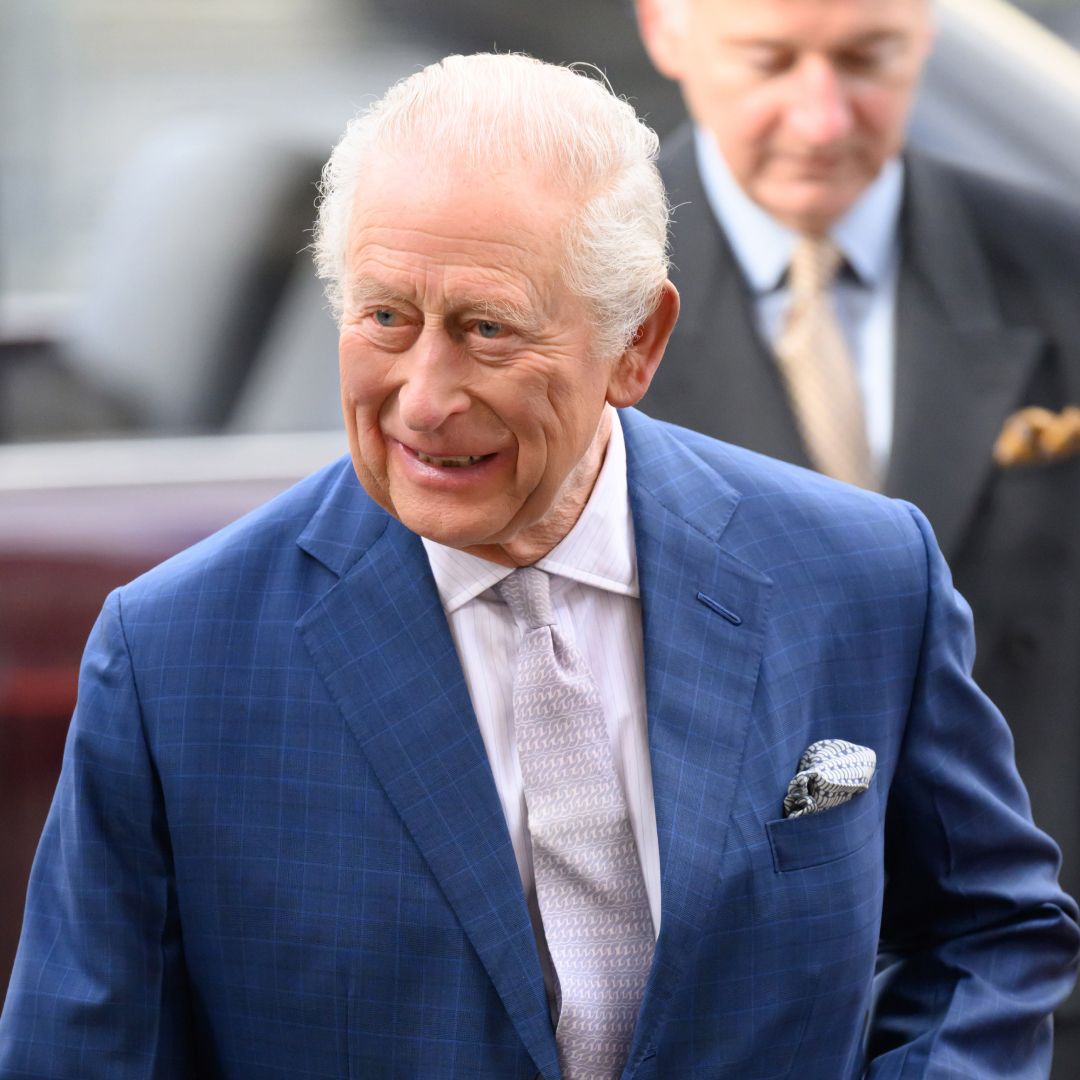 King Charles wearing a blue suit and smiling