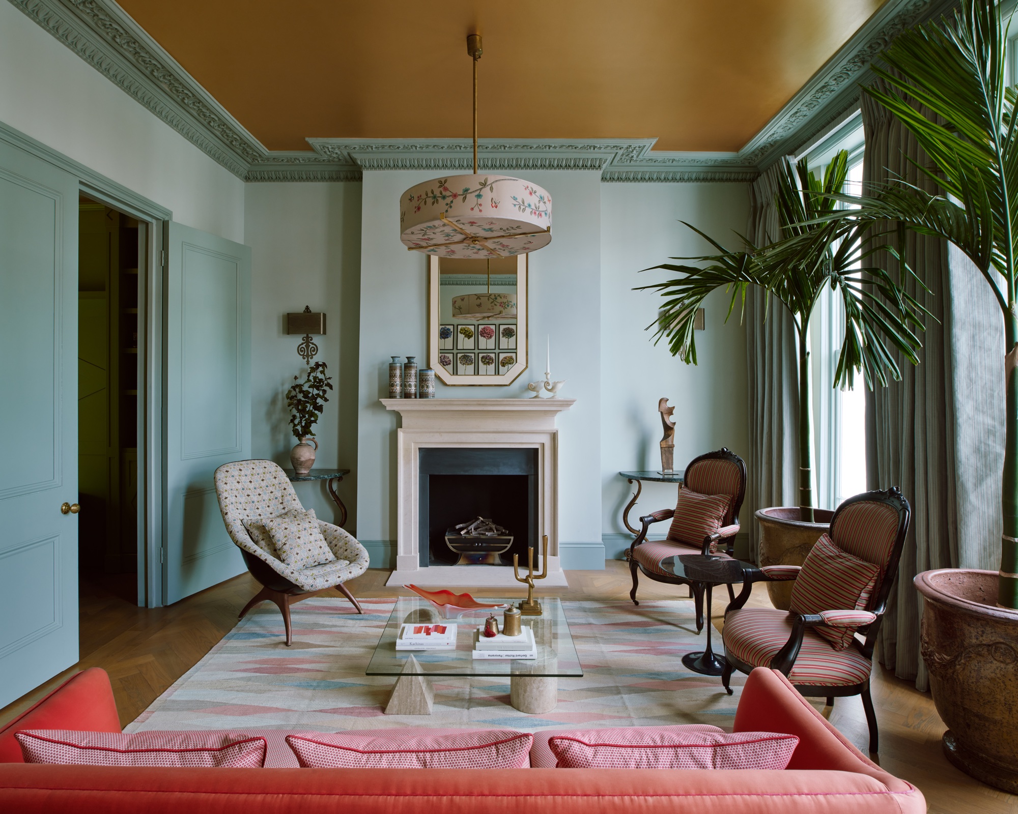 Blue living room with pink sofa and ochre ceiling by Maddux Creative