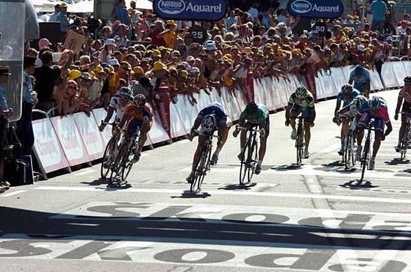 The Belgian throws his bike over the line just before Freire in orange on the left and Zabel on the right.