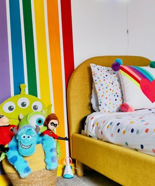 kids' bedroom with rainbow mural and yellow bedframe