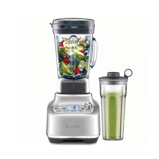 A Breville Super Q blender filled with fruit and with its personal blender attachment