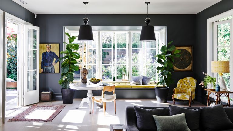 Black living room ideas with yellow furniture and soft furnishings and large windows.