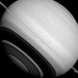 This image from the Cassini space probe shows Saturn's rings edge-on. Many details of the rings can be seen in the shadow they cast on the body of the planet.