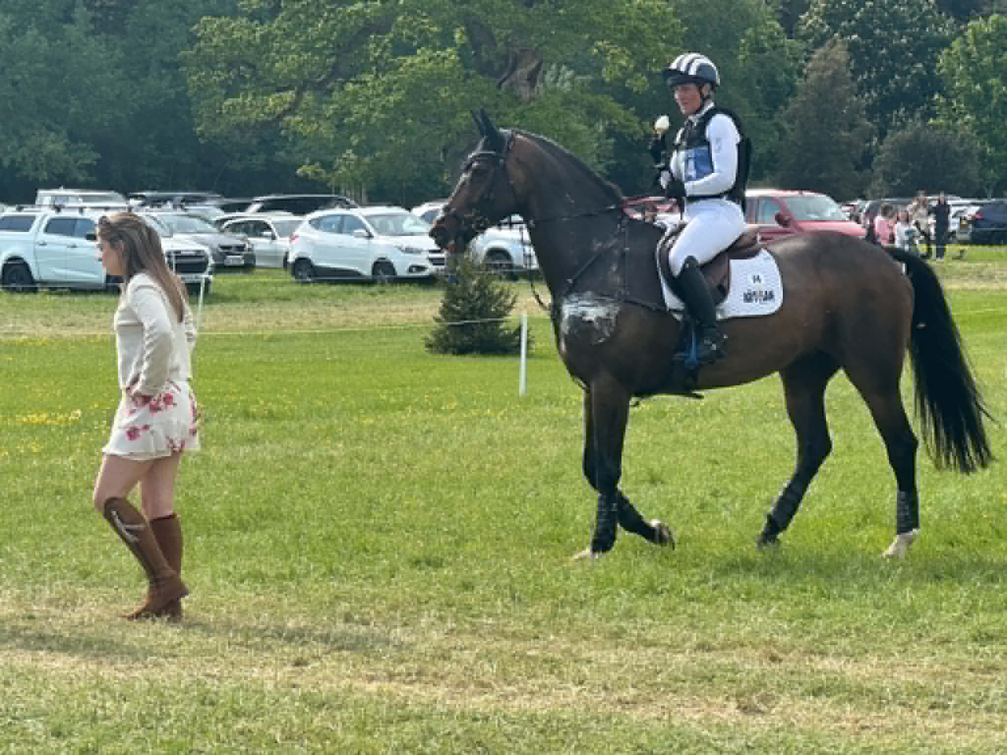 Caroline Powell tucks into an ice cream as she heads back after retiring on course at Badminton 2026.