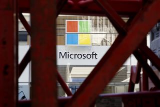 Microsoft and AWS: Microsoft logo seen through a gap in a red metal bridge