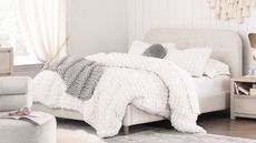 White bed with grey throw blanket