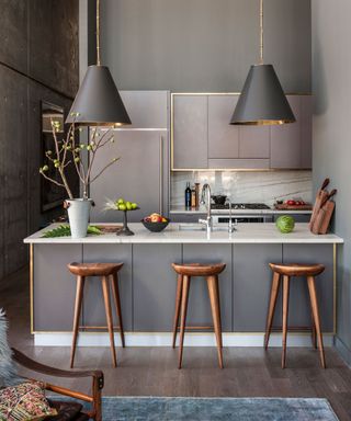 Grey kitchen with pendant and wood stools