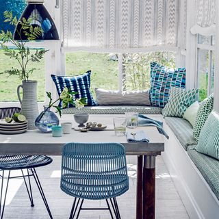 A conservatory with blinds and blue decor