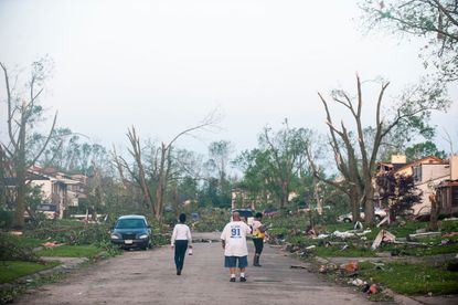People look at damage caused by tornadoes near Dayton, Ohio.