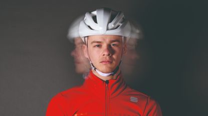 Blurry image of a male cyclist wearing a helmet, used to depict the dizzyness experienced from a concussion following a cycling crash