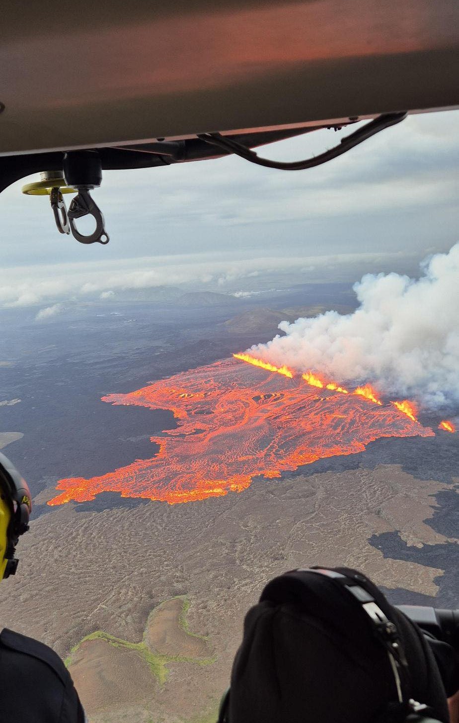 An aerial photograph of lava flowing out across the landscape on Iceland's Sundhnúkur crater row.