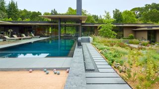 An example of backyard landscaping ideas with a pool and bocce court