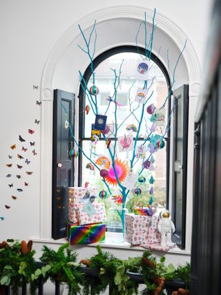 Blue twig Christmas tree with decorations in a window