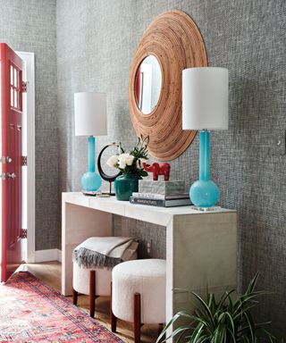 Grey textured wallpaper, blue lamps, wooden mirror