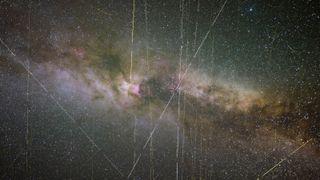 clouds of grey, white, and purple swirl over a black background