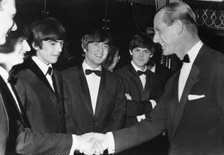 Prince Philip young (R) has just been confirmed a loyal Beatle fan as he shakes with the Beatle drummer Ringo Starr while other Beatles (L to R) George Harrison, John Lennon and Paul McCartney look on.