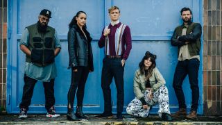 Guz Khan, Nathalie Emmanuel, Matthias Schweighöfer, Ruby O. Fee, and Stuart Martin posing in front of a big blue door in Army Of Thieves.