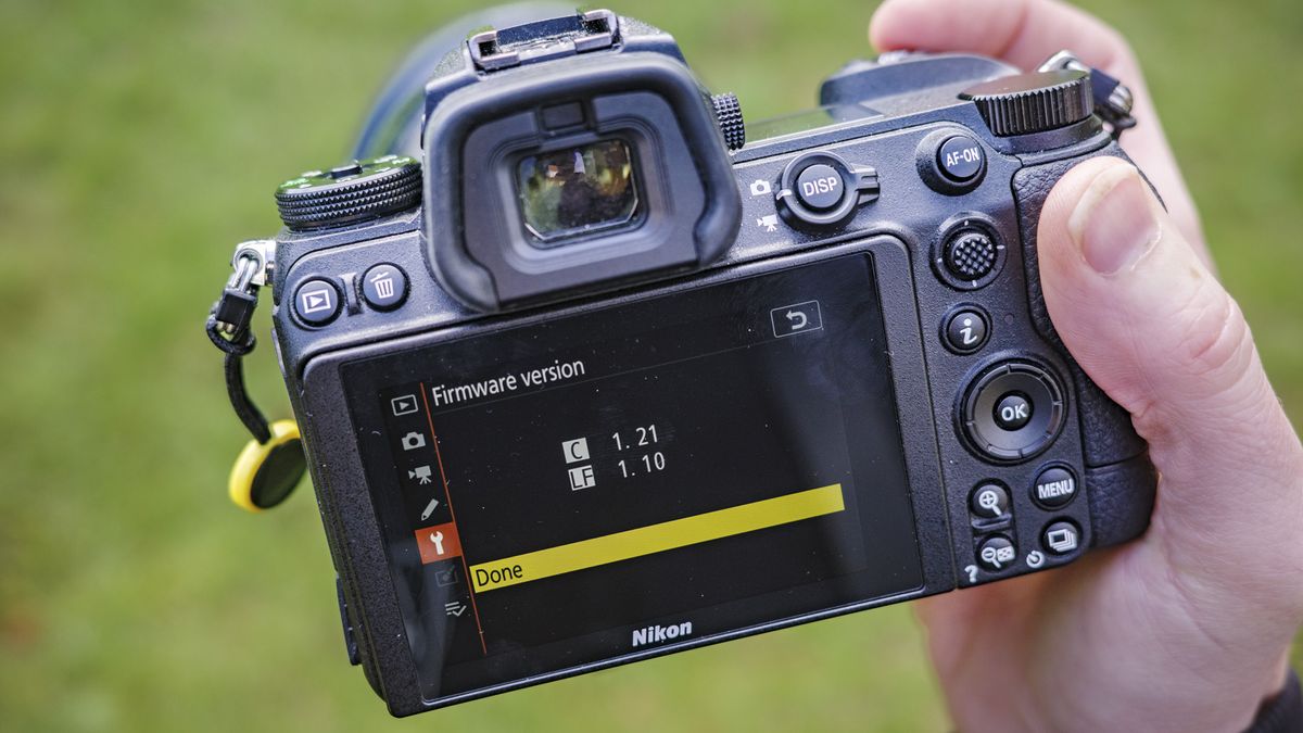 Nikon Z6 ii camera in the hand with its firmware version displayed on rear screen