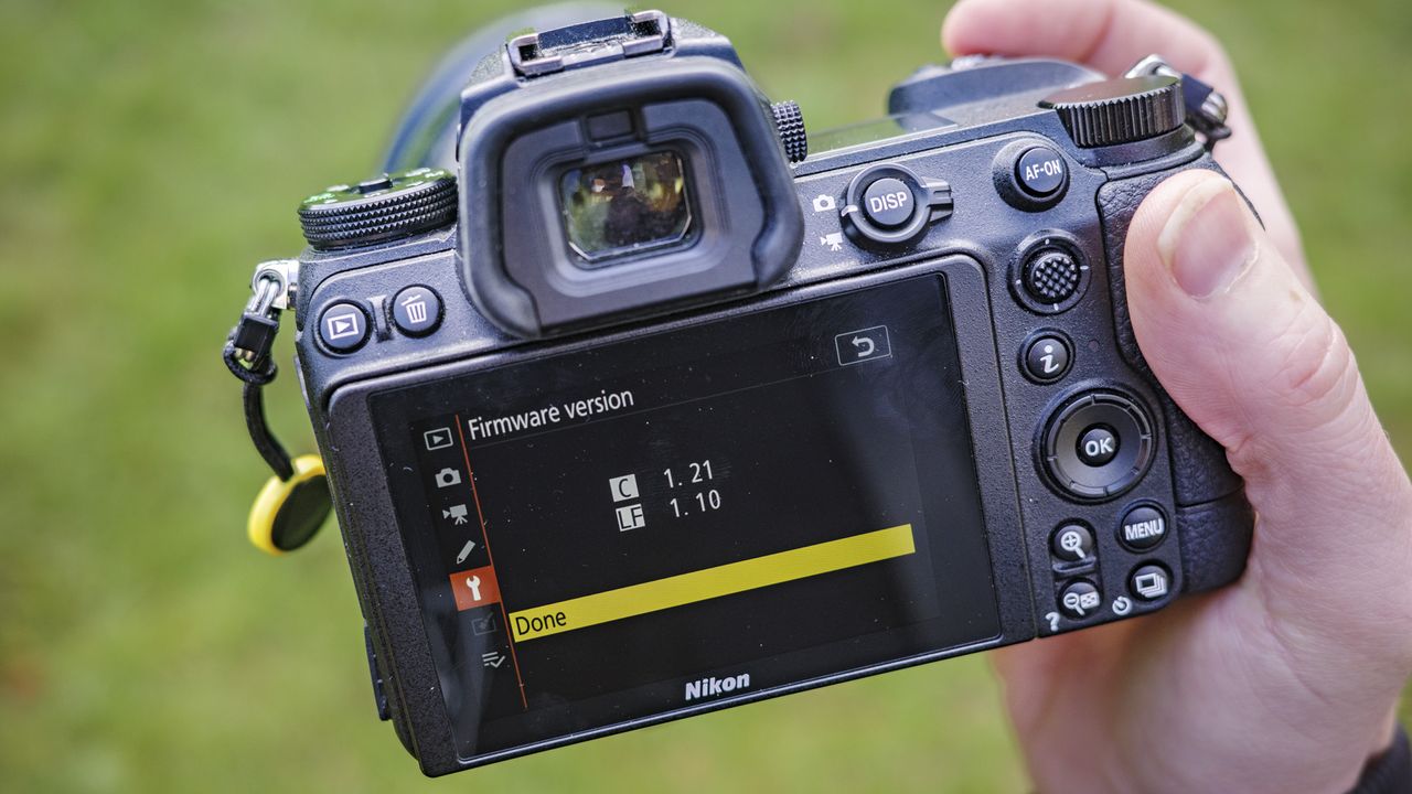 Nikon Z6 ii camera in the hand with its firmware version displayed on rear screen