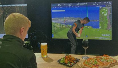 A golfer swings in the simulator 