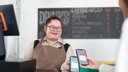 Girl taking cashless payments in cafe