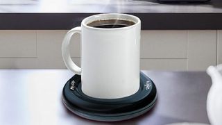 A coffee cup on a "Mr Coffee" USB mug warmer