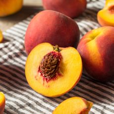 Cut peach with exposed pit on a striped towel