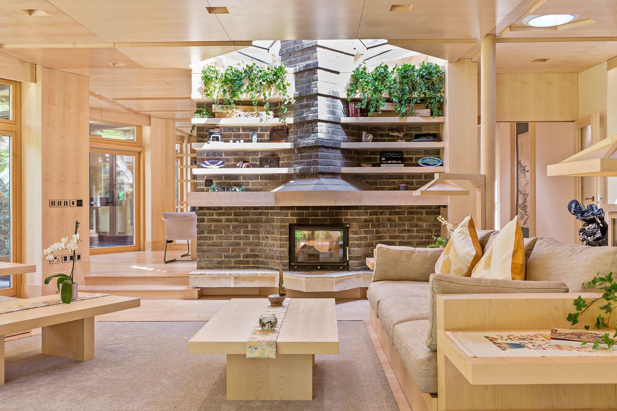 A wood burner in a neutral living room with a sofa visible