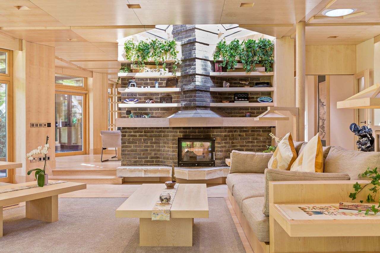 A wood burner in a neutral living room with a sofa visible