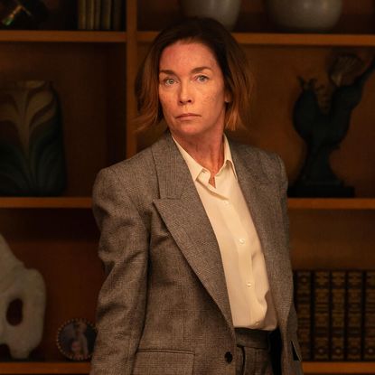 julianne nicholson as sinatra wearing a grey suit standing in an office in the paradise season 1 finale